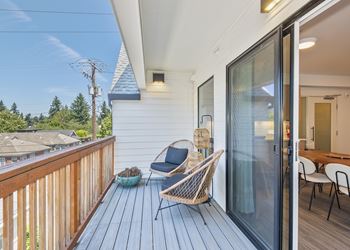 A wooden deck with a chair and a table.